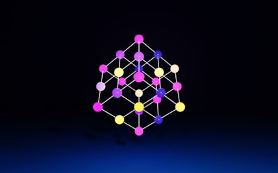 A geometric structure composed of multicolored spheres connected by lines, forming a three-dimensional lattice against a dark background.