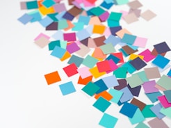 a pile of multicolored confetti sitting on top of a white table