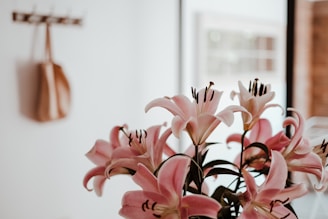 a vase filled with pink flowers on top of a table