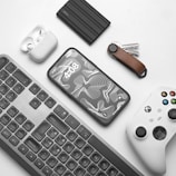 a keyboard, mouse, controller, and other items on a table