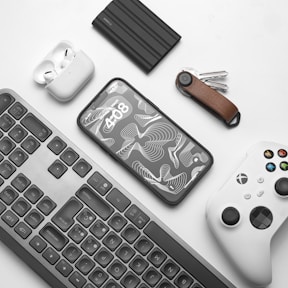 a keyboard, mouse, controller, and other items on a table