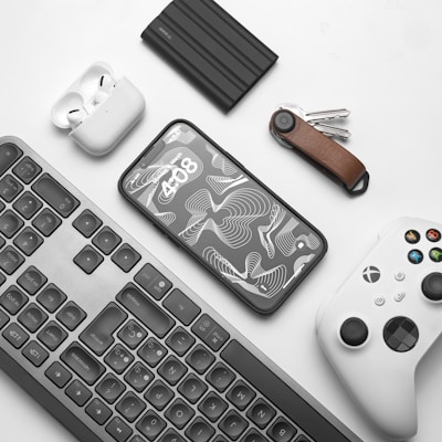 a keyboard, mouse, controller, and other items on a table