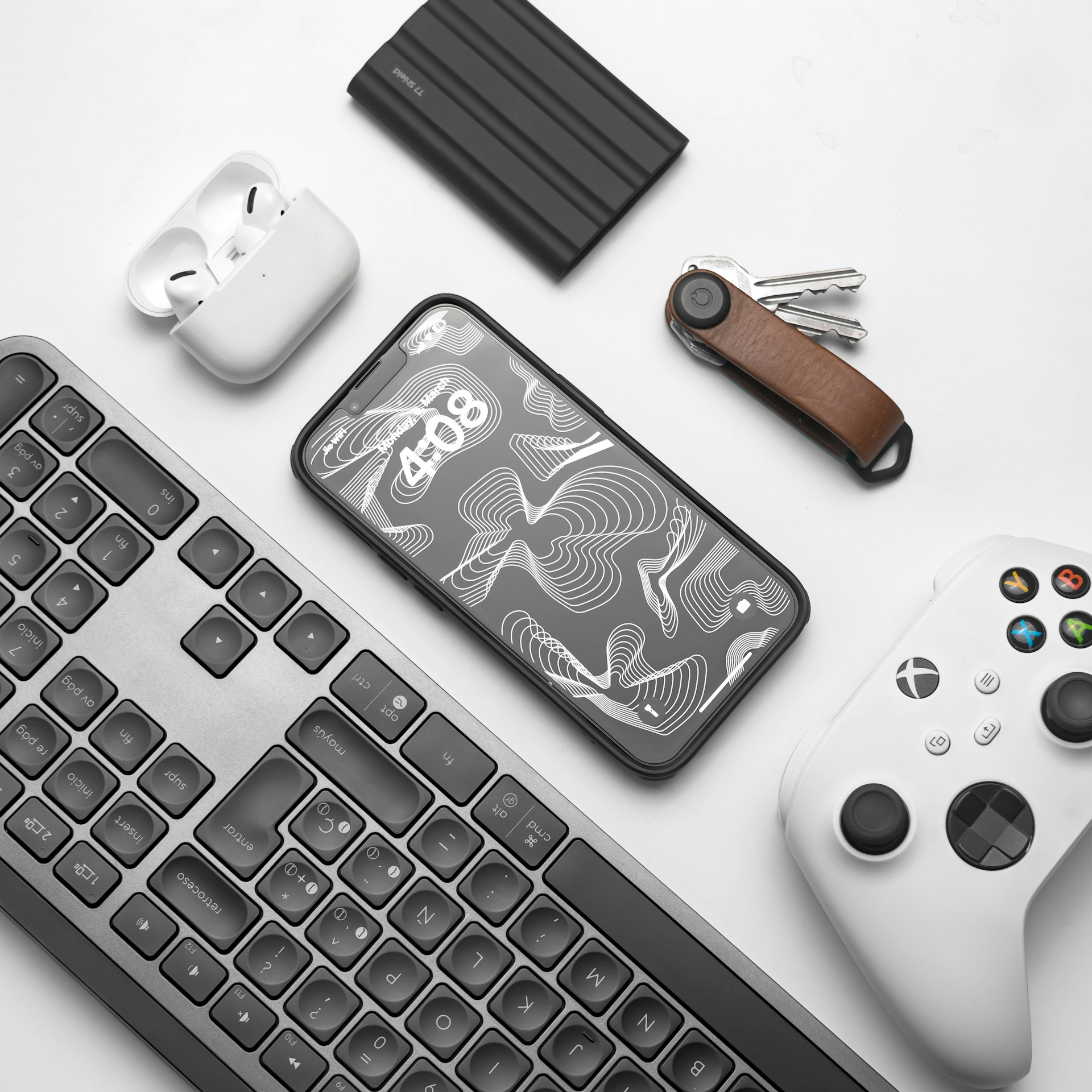 a keyboard, mouse, controller, and other items on a table