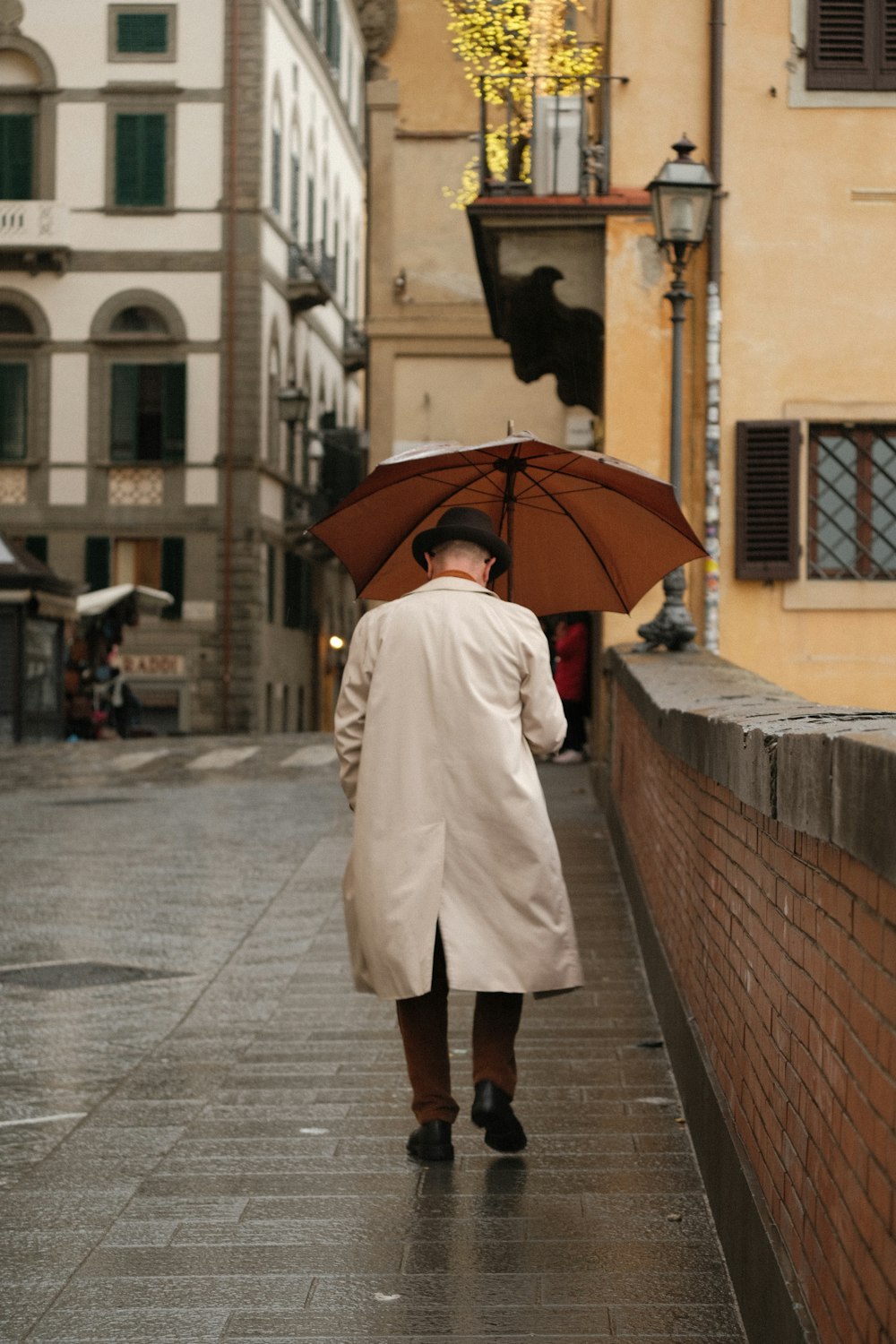 a woman walking down a street holding an umbrella