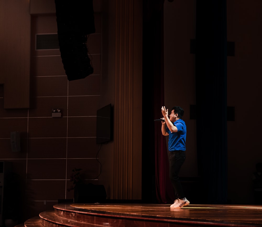 a man standing on top of a stage holding a cell phone