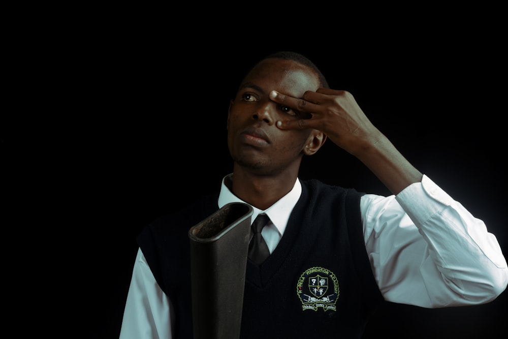 a man in a vest and tie adjusts his tie