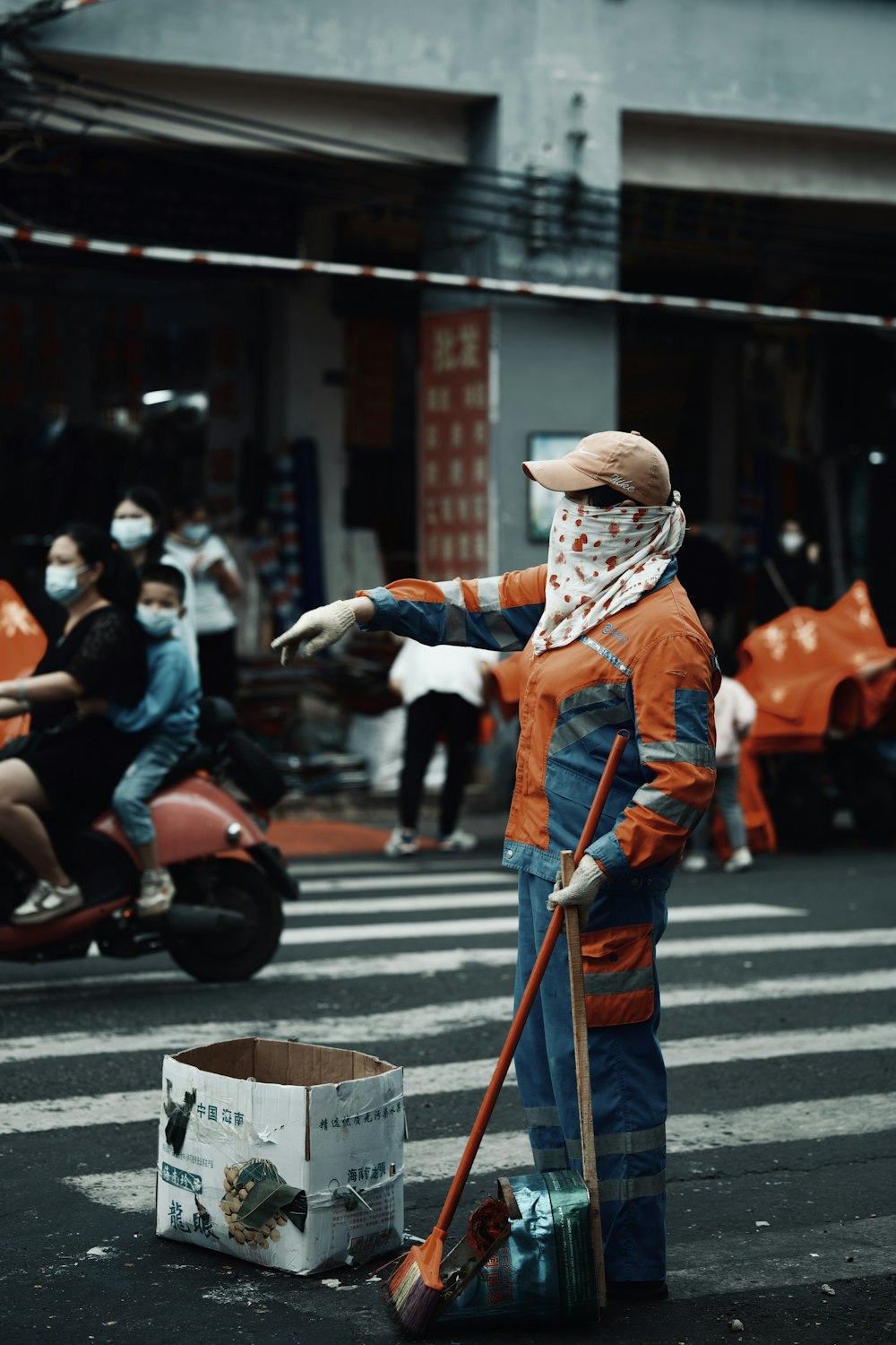 a person in an orange and blue outfit with a broom