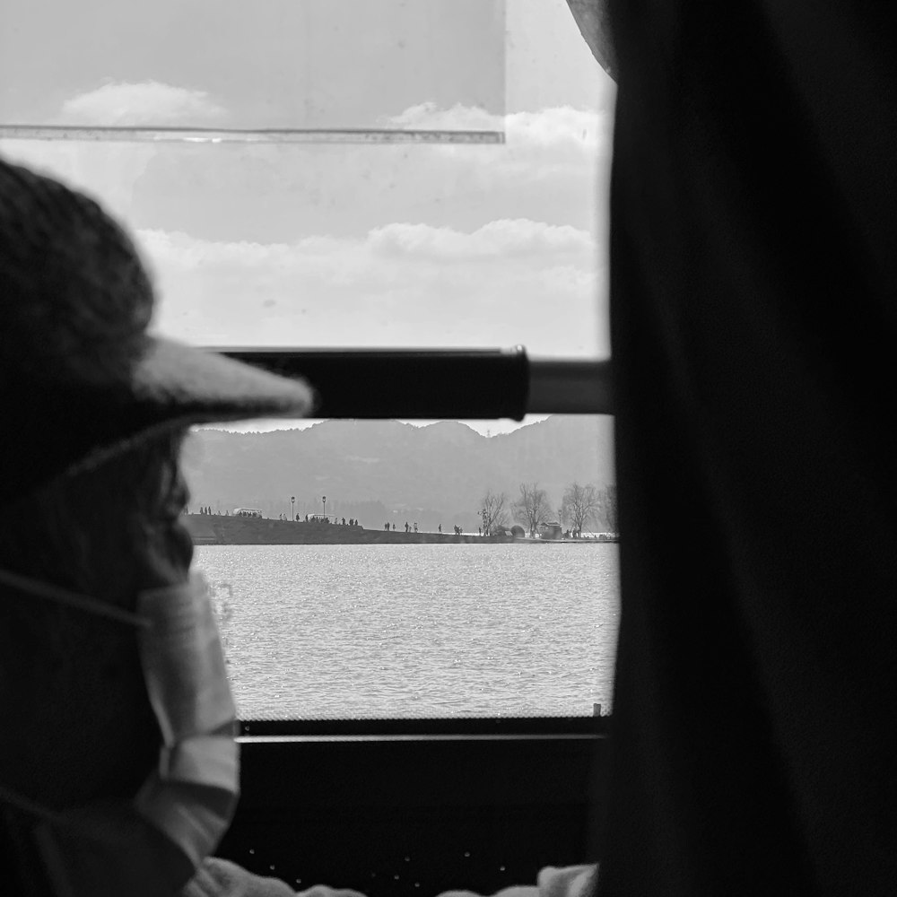 a person wearing a hat looking out a window
