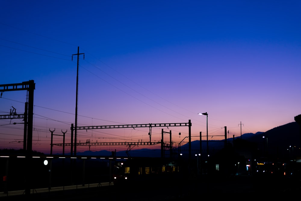 a train traveling down train tracks at dusk