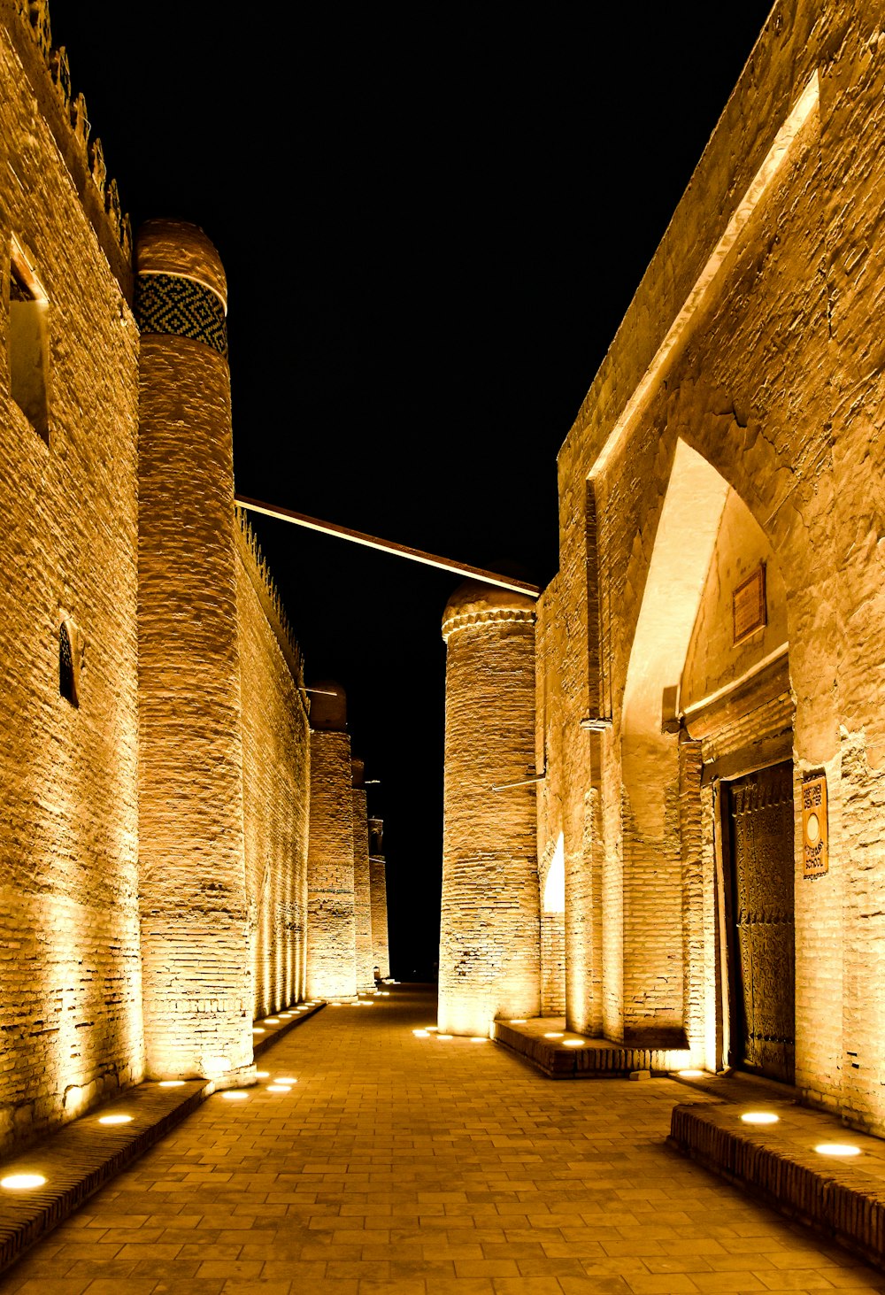 a brick walkway with a clock tower in the background