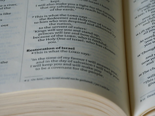 Close-up of an open ancient scripture with gentle shadows on a wooden table