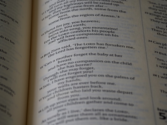 The page in the image contains text from a Bible open to a section with numbered verses. The text is printed in black ink on cream-colored paper, with varying font sizes for headings and verses.
