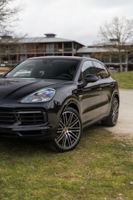 a black porsche cayen is parked on the side of the road