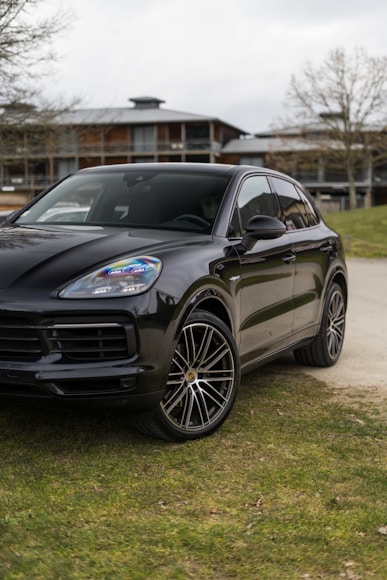 a black porsche cayen is parked on the side of the road