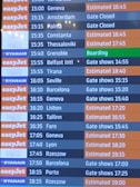 A flight departure board displaying various airlines and their scheduled flights. The board shows destinations, companies such as EasyJet, Ryanair, and Wizz, departure times, and status updates like 'Gate Closed', 'Estimated', or 'Boarding'. The background color for EasyJet is orange, Ryanair is blue, and Wizz is purple, with corresponding flight status updates in different colors.