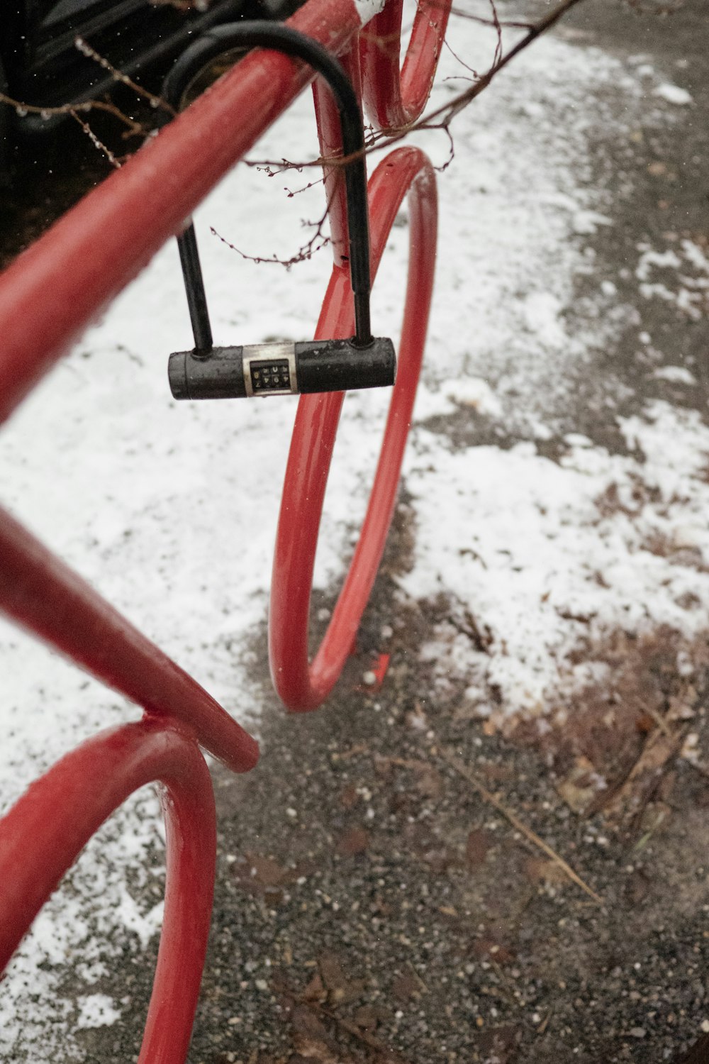 a close up of a red bike with snow on the ground