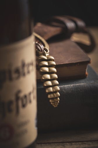 A close-up of a delicate, pastel-colored minimalist keychain resting on a wooden table.