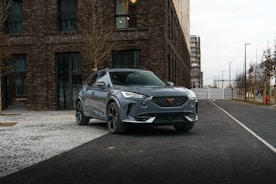 a grey suv parked in front of a brick building
