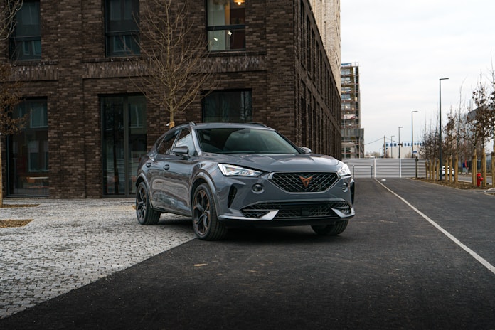a grey suv parked in front of a brick building