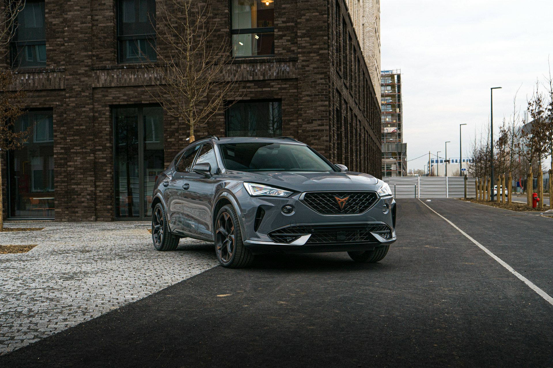 a grey suv parked in front of a brick building