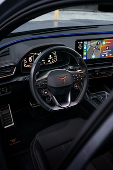the interior of a car with a steering wheel and dashboard