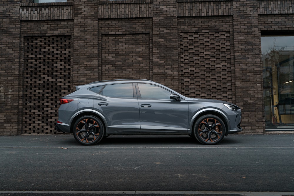 a grey suv parked in front of a brick building