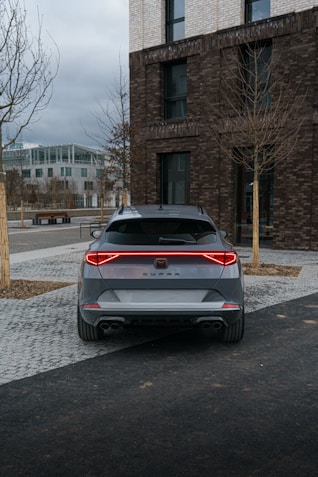a grey car parked in front of a brick building