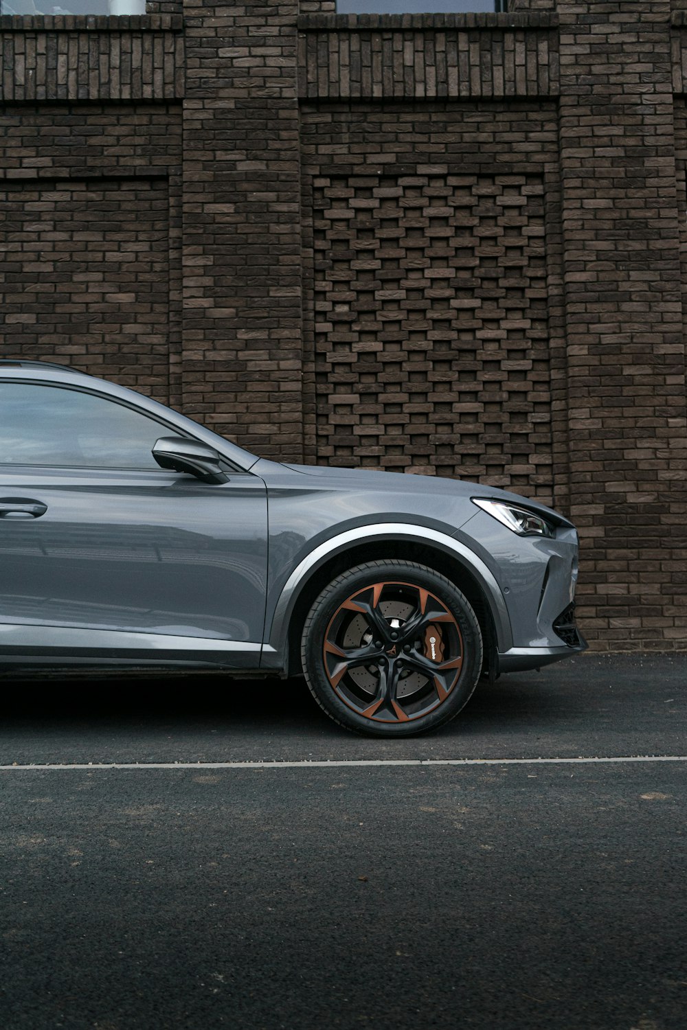 a silver sports car parked in front of a brick building