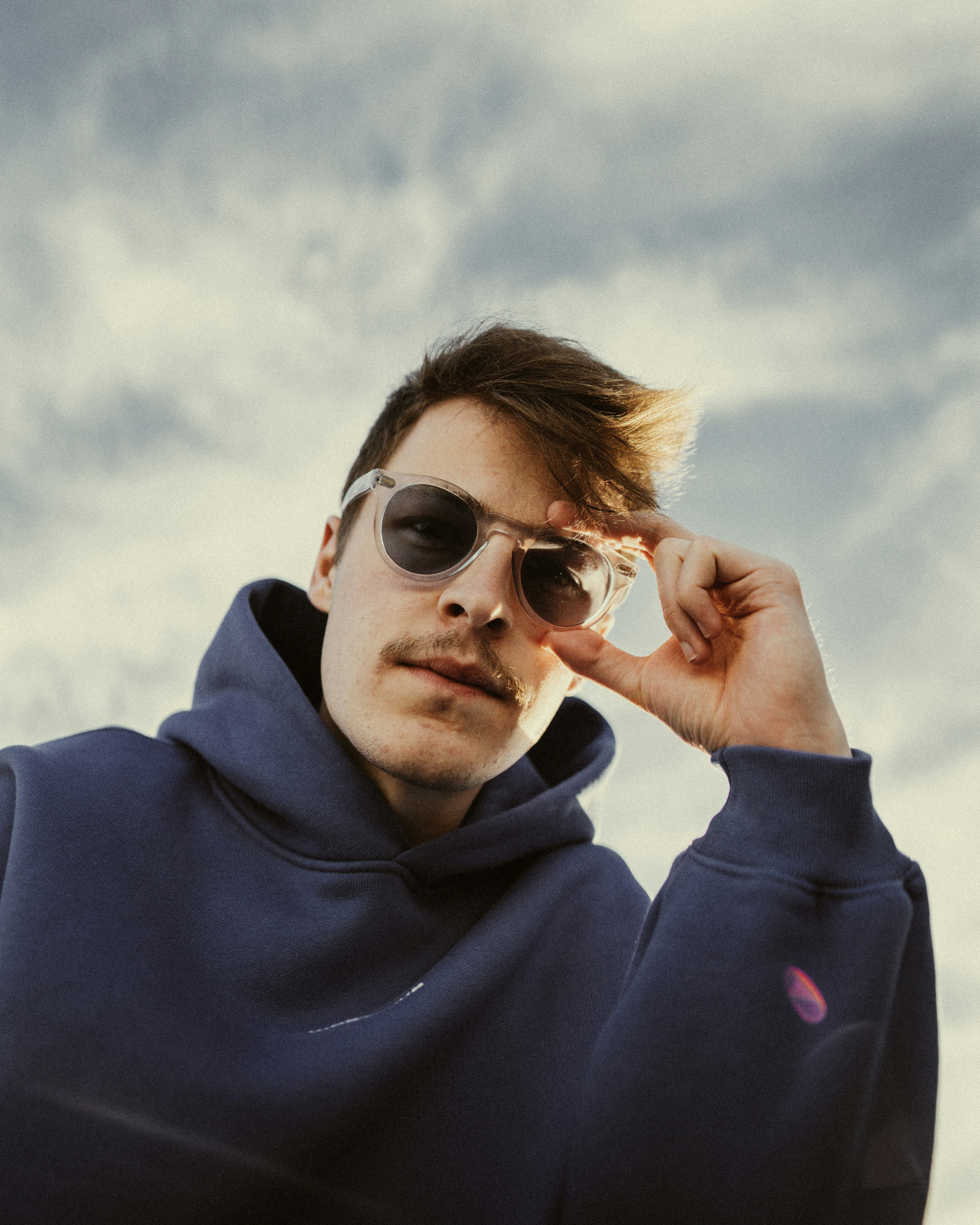a man in a blue hoodie and sunglasses