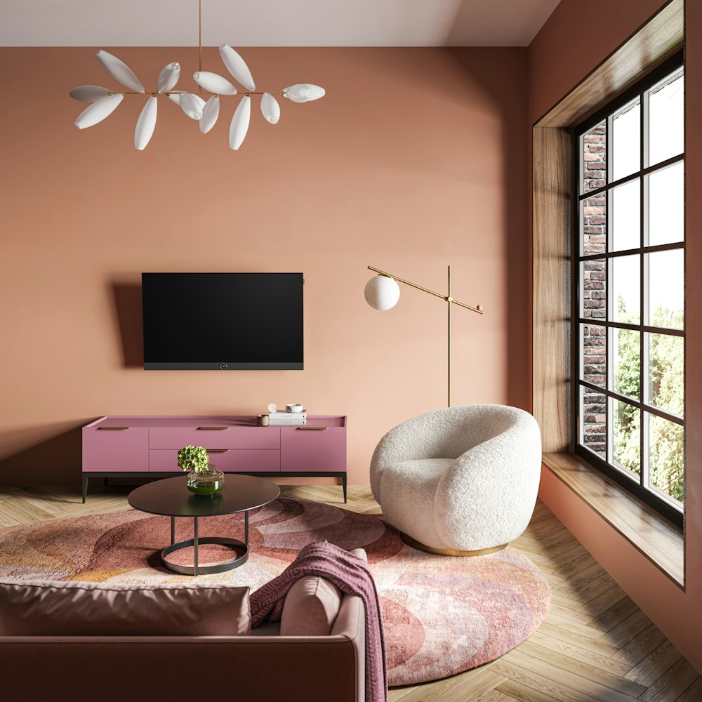 a living room with pink walls and a white chair