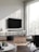A modern living room featuring a wall-mounted TV with a sleek sound system underneath.