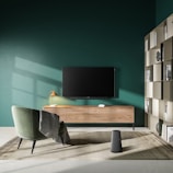 a living room with green walls and a tv