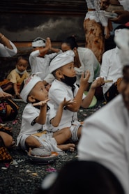 a group of young children sitting on the ground