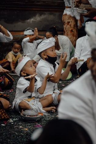 a group of young children sitting on the ground