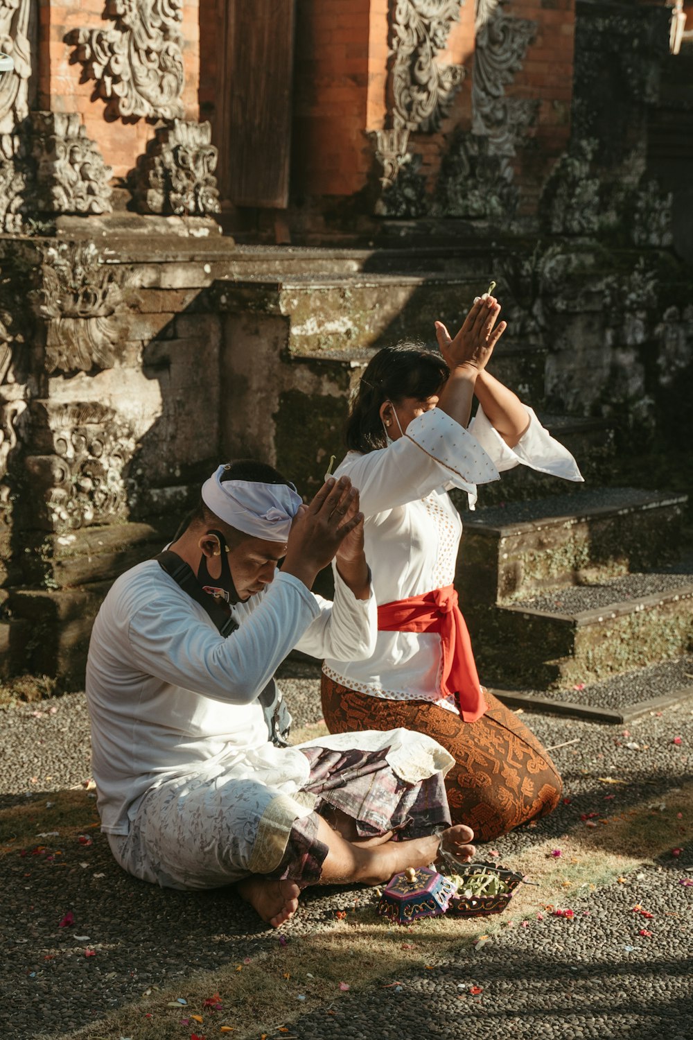 a man kneeling down next to a woman on the ground