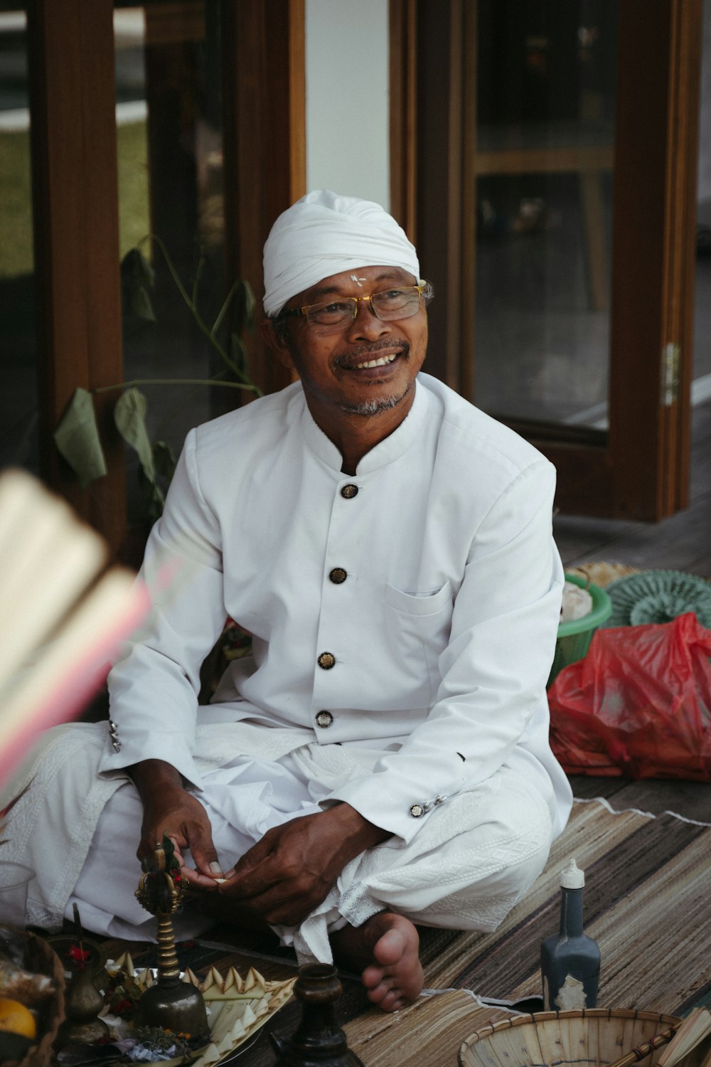 a man in a white outfit sitting on the ground