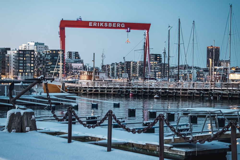 a harbor with boats and a crane in the background