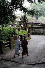 Tourists enjoying a cultural walk through Viseisei village with lush greenery around.
