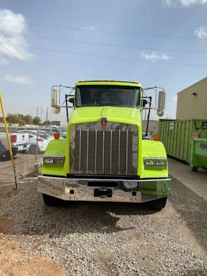 A bright Celion truck parked in front of a residential area, ready for waste pickup.