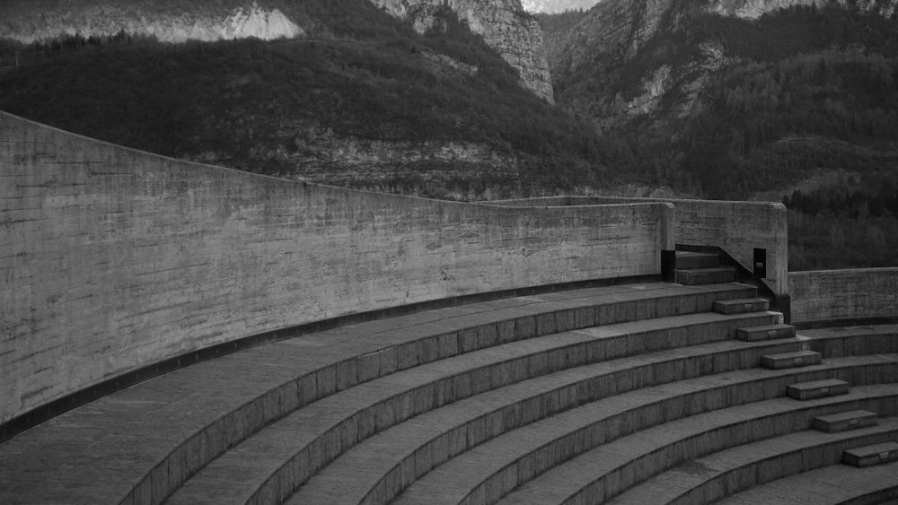 a black and white photo of a stage with mountains in the background