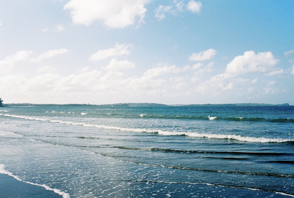 a beach with a boat in the distance