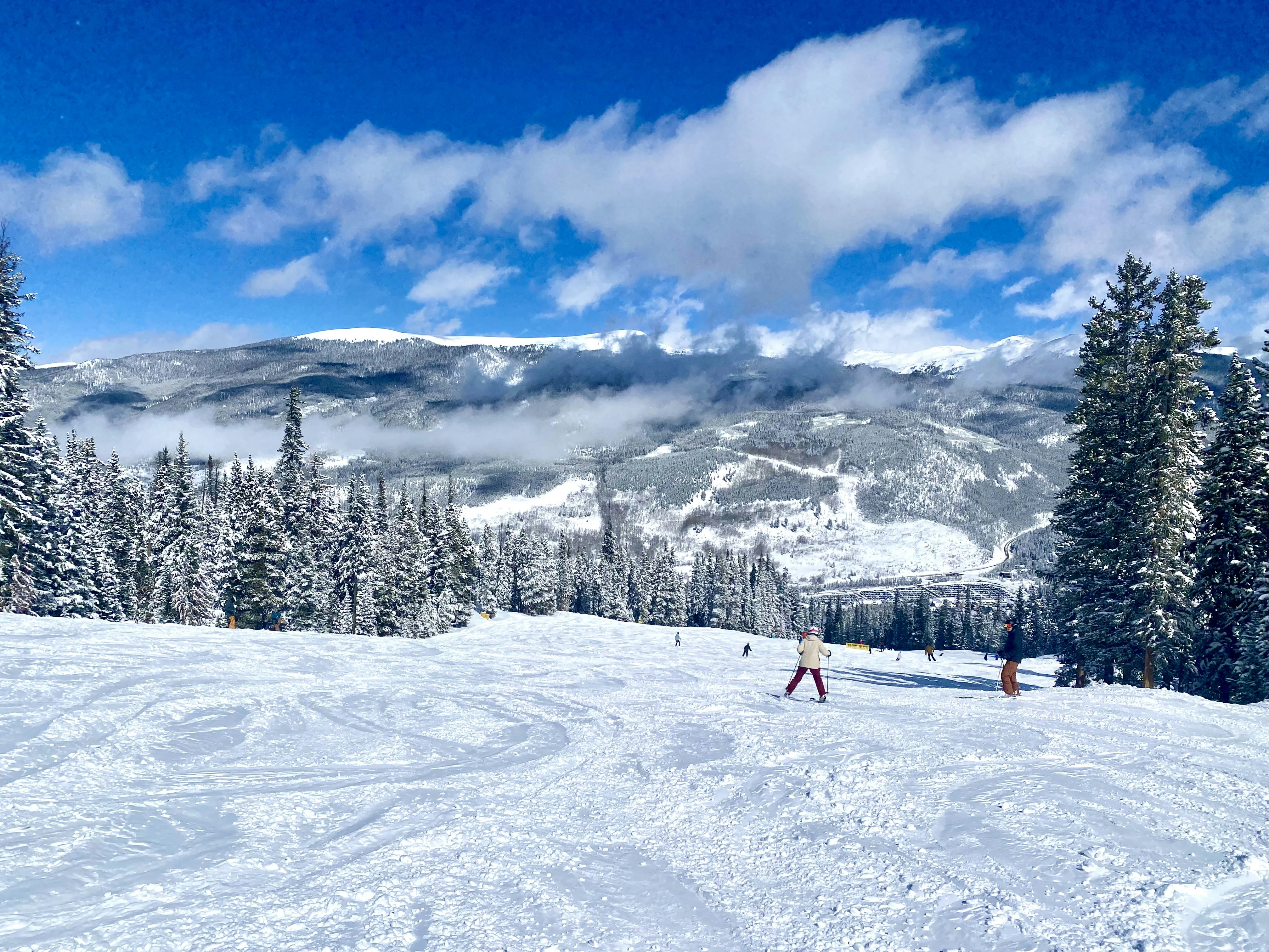 a group of people riding skis on top of a snow covered slope