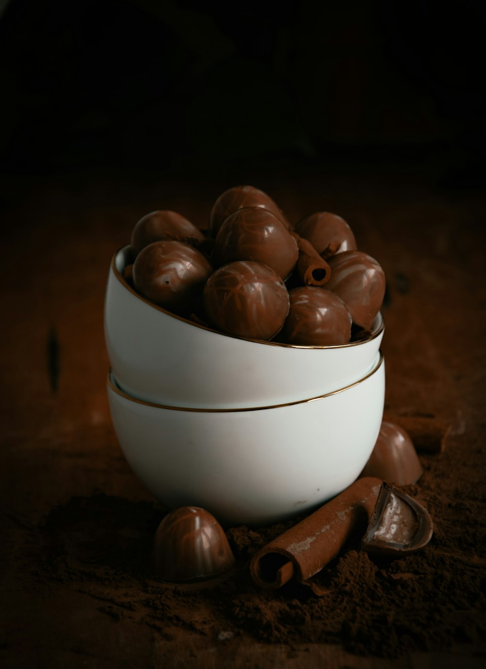a white bowl filled with chocolate covered nuts
