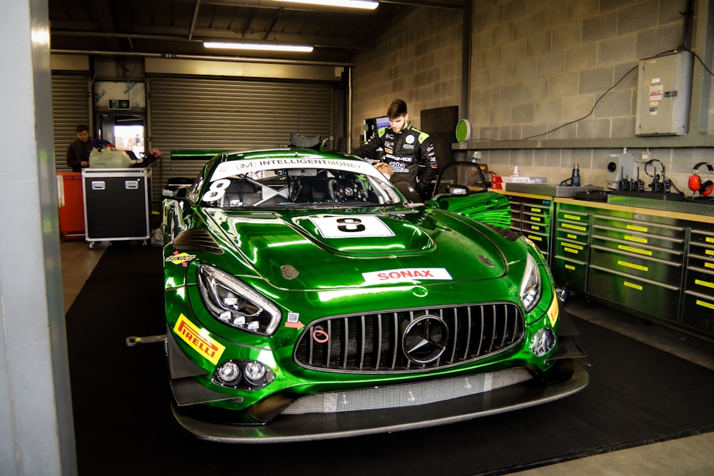 a green mercedes sports car in a garage