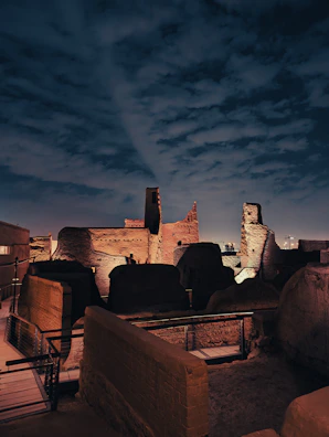 Ancient archaeological ruins bathed in deep purple twilight.