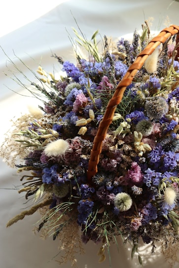 Close-up of a delicate arrangement of wildflowers in a rustic wicker basket, perfect for home decoration.