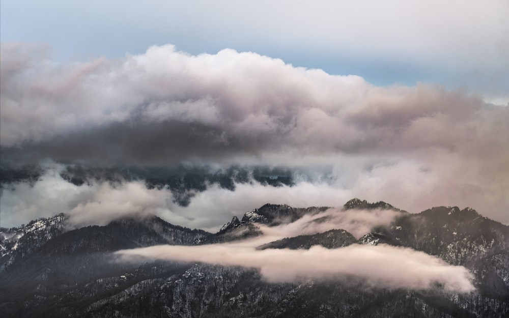 a view of a mountain range covered in clouds