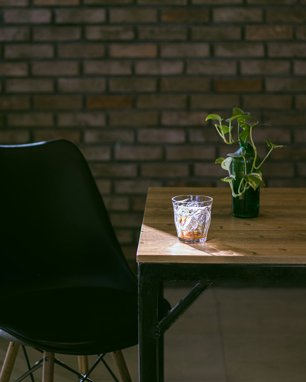 a table with a glass and a potted plant on it