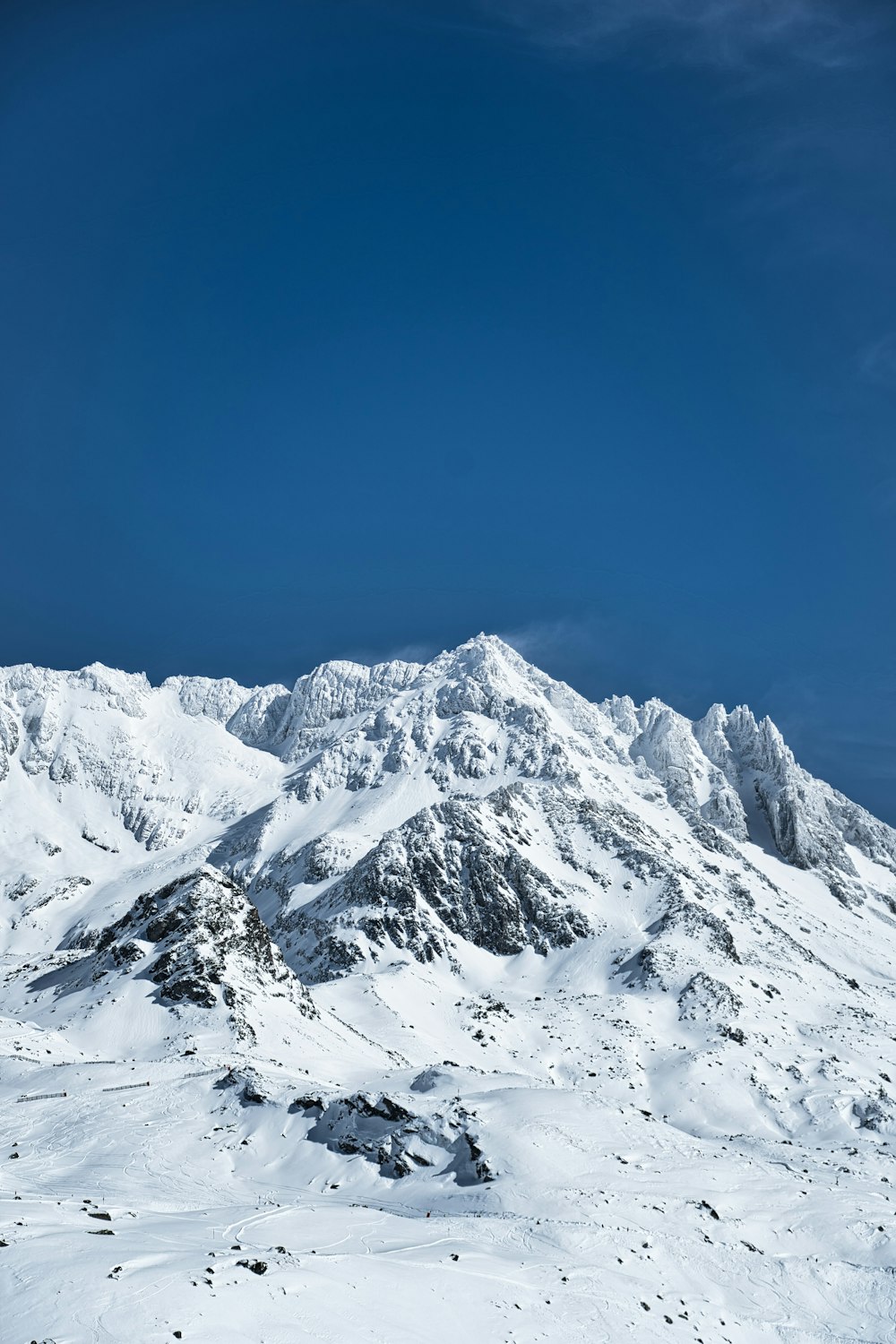 a mountain covered in snow under a blue sky