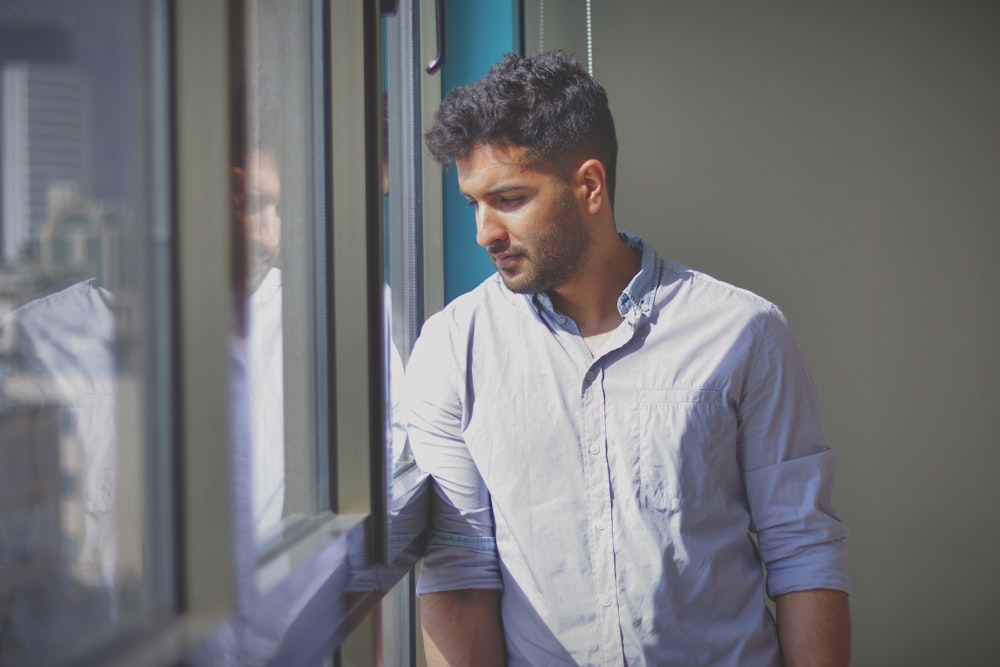 a man looking out the window of a building